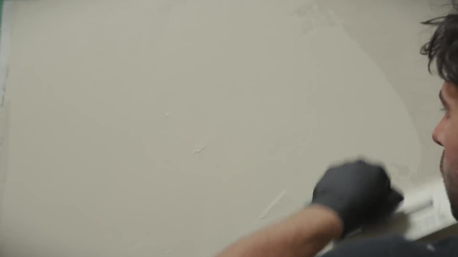 Installer hand-troweling microcement onto a wall